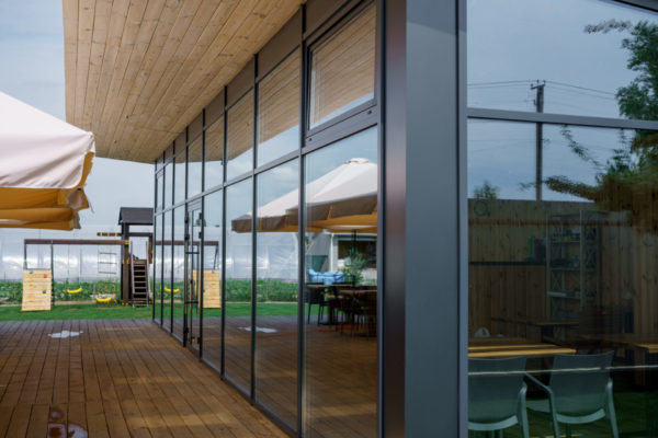 Elegant wooden home terrace with balcony. doors from bathroom and bedroom. Panorama of spacious terrace with wooden floor and furniture and amazing view.